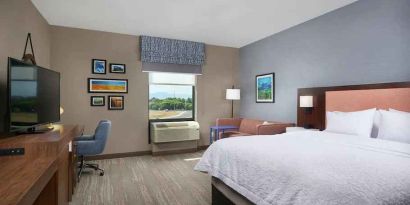 King bedroom with desk, window and sofa at the Hampton Inn Burley.