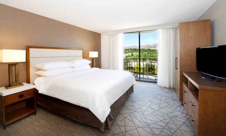 King bedroom with window at the Embassy Suites by Hilton Colorado Springs.