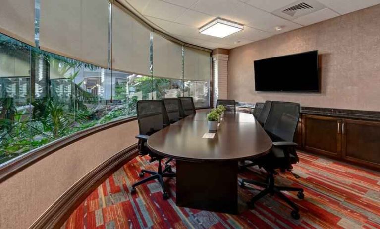 Meeting room with round table and TV screen at the Embassy Suites by Hilton Colorado Springs.