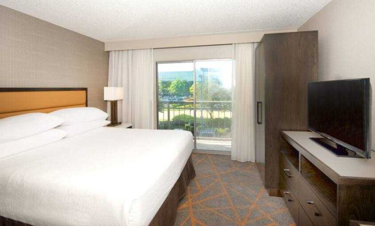 King bedroom with window and TV screen at the Embassy Suites by Hilton Cincinnati Blue Ash.