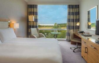 King guestroom with desk and TV screen at the Hilton Reading.