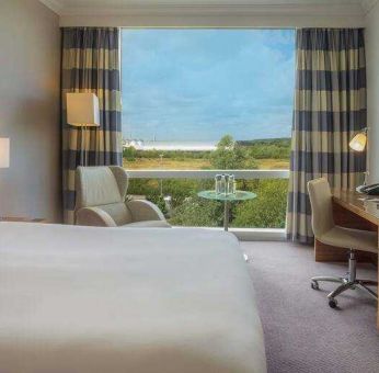 King guestroom with desk and TV screen at the Hilton Reading.