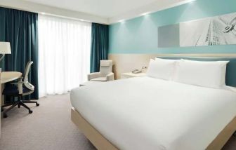 King bedroom with desk at the Hampton by Hilton London Docklands.