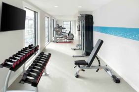 Bright fitness room with weights at the Hampton by Hilton London Docklands.