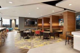 Lobby workspace with tables and chairs at the Hampton by Hilton London Docklands.