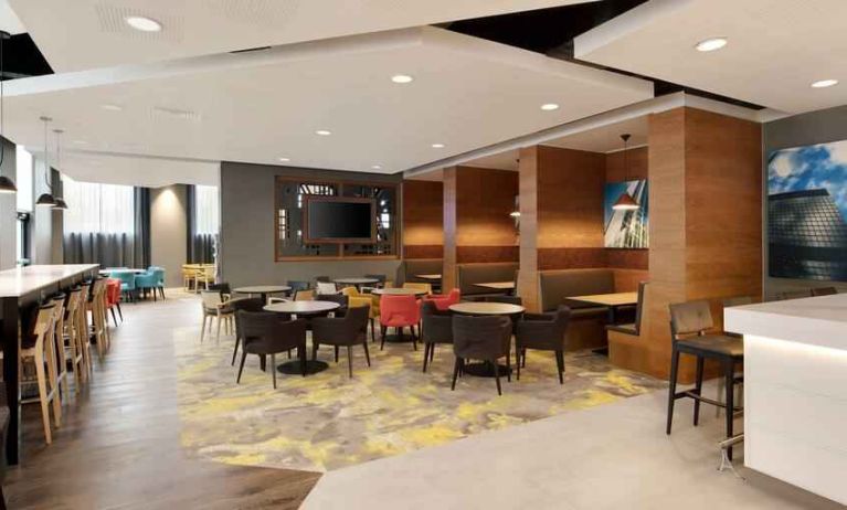 Lobby workspace with tables and chairs at the Hampton by Hilton London Docklands.