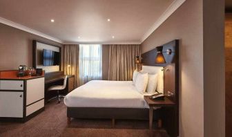 King bedroom with TV screen and desk at the DoubleTree by Hilton London - Ealing.