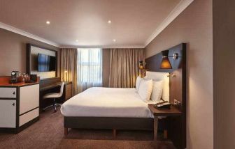 King bedroom with TV screen and desk at the DoubleTree by Hilton London - Ealing.