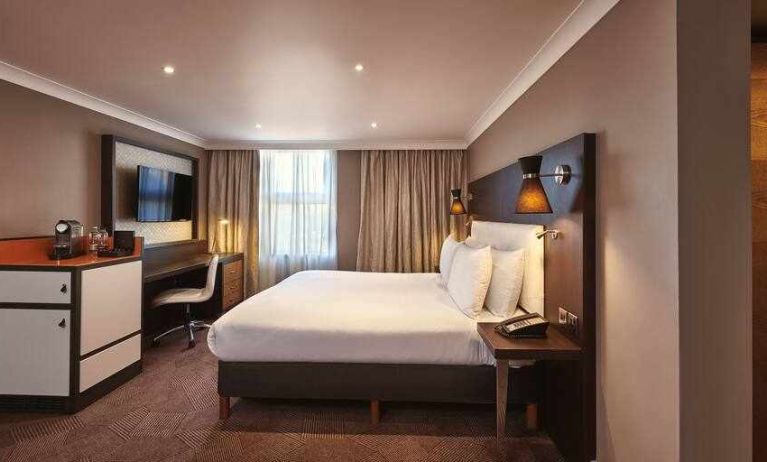 King bedroom with TV screen and desk at the DoubleTree by Hilton London - Ealing.