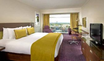 spacious king suite with work area and TV at Hilton London Metropole.