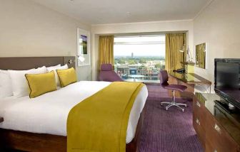 spacious king suite with work area and TV at Hilton London Metropole.