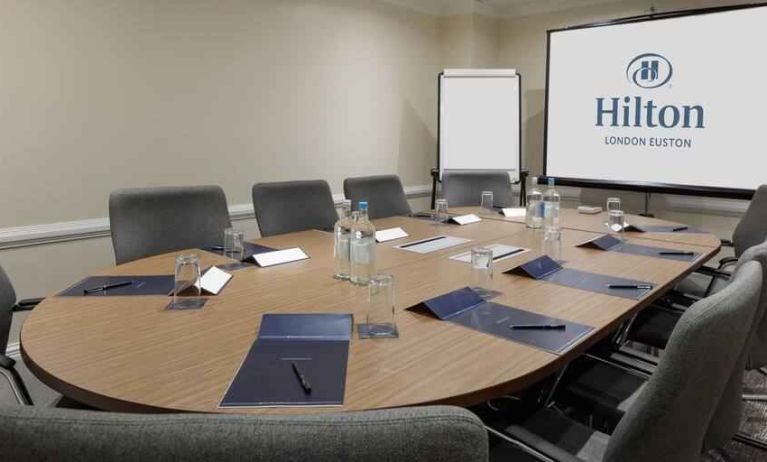 Meeting room with screen and blackboard at the Hilton London Euston.