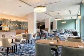 Hotel workspace with tables and chairs at the Hilton London Gatwick Airport.