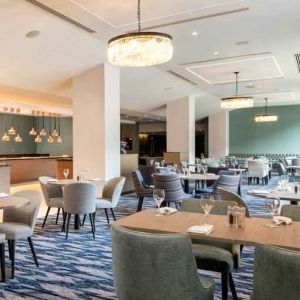 Hotel workspace with tables and chairs at the Hilton London Gatwick Airport.