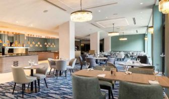 Hotel workspace with tables and chairs at the Hilton London Gatwick Airport.