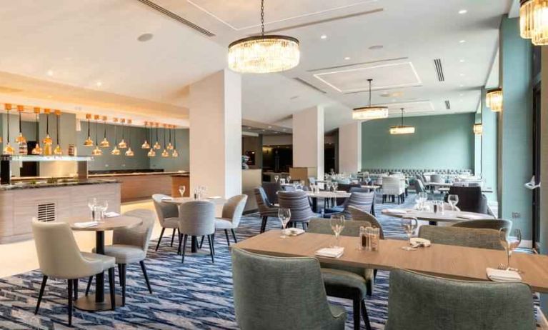 Hotel workspace with tables and chairs at the Hilton London Gatwick Airport.