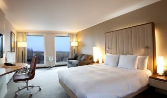 King guestroom with desk and sofa at the Hilton London Heathrow Airport Terminal 5.