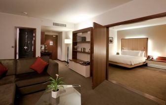 Deluxe suite with king size bed and sofa at the Hilton London Heathrow Airport Terminal 5.