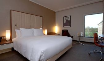 King bedroom with window at the Hilton London Heathrow Airport Terminal 5.