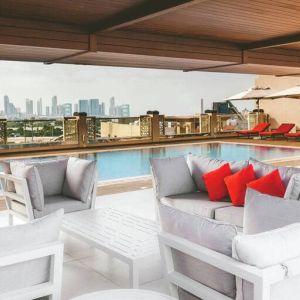 Rooftop pool with seating overlooking a city view at the Hilton Dubai Al Jadaf.