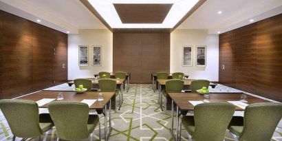 Large coworking or conference meeting room with six tables of four seats each,