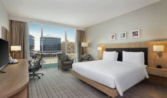 King-sized bed with view of city buildings at the Hilton Garden Inn Dubai Mall of the Emirates.