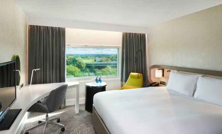 King bedroom with desk and window at the Hilton London Heathrow Airport.