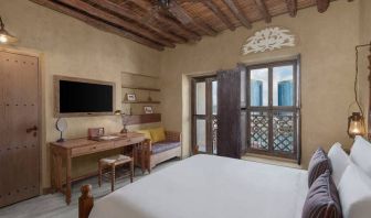 King bed with large TV and spacious workstation at the Al Seef Heritage Hotel Dubai, Curio Collection by Hilton.