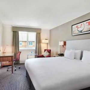 King bedroom with TV screen and desk at the DoubleTree by Hilton Bristol North.