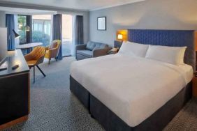 Bright king bedroom with windows and desk at the DoubleTree by Hilton Manchester Airport.