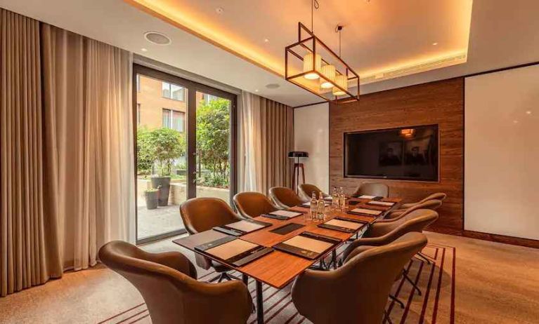 Small meeting room with TV screen at the Fellows House Cambridge, Curio Collection by Hilton.