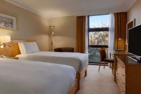 Twin room with desk and TV screen at the Hilton London Kensington.