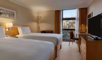 Twin room with desk and TV screen at the Hilton London Kensington.