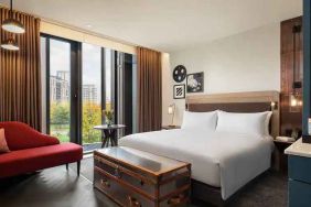 King suite with large window and sofa at the Gantry London, Curio Collection by Hilton.