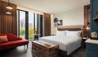 King suite with large window and sofa at the Gantry London, Curio Collection by Hilton.