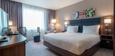 King bedroom with desk and TV screen at the Hilton Garden Inn Birmingham Airport UK.