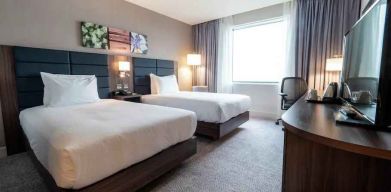 Comfortable twin room with working station at the Hilton Garden Inn Birmingham Airport UK.