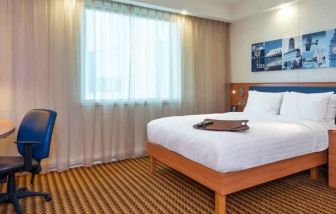Hotel bedroom with desk at the Hampton by Hilton London Luton Airport.