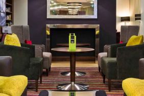 Lobby workspace by the fireplace at the Hampton by Hilton London Luton Airport.