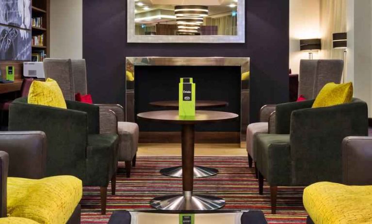 Lobby workspace by the fireplace at the Hampton by Hilton London Luton Airport.