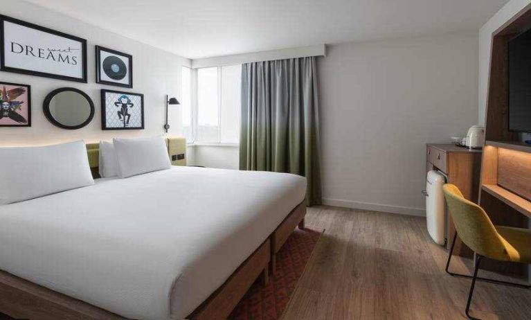 Bright king guestroom with desk at the Hampton by Hilton London Ealing.