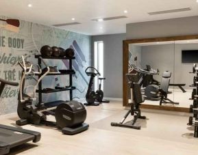 Fitness center with weights and machines at the Hampton by Hilton London Ealing.