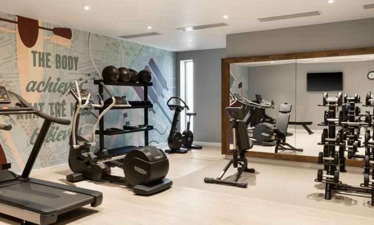 Fitness center with weights and machines at the Hampton by Hilton London Ealing.