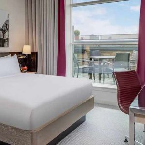 comfortable delux king bed with lots of natural light, work desk, and outside terrace at Hilton London Angel Islington.