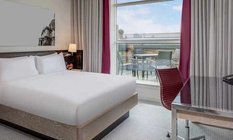 comfortable delux king bed with lots of natural light, work desk, and outside terrace at Hilton London Angel Islington.