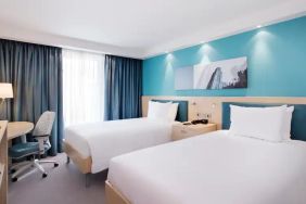 Twin room with TV screen and desk at the Hampton by Hilton Bristol Airport.