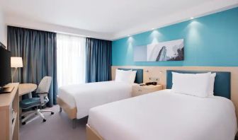 Twin room with TV screen and desk at the Hampton by Hilton Bristol Airport.