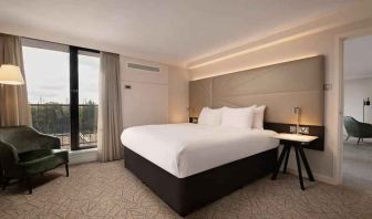 Bright king bedroom with sofa along the window at the Hilton Birmingham Metropole.