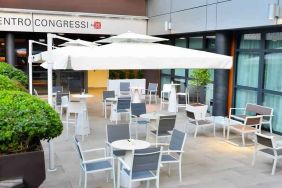 Outdoor terrace with sun umbrellas, chairs and tables at the Hilton Garden Inn Milan North.