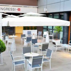 Outdoor terrace with sun umbrellas, chairs and tables at the Hilton Garden Inn Milan North.